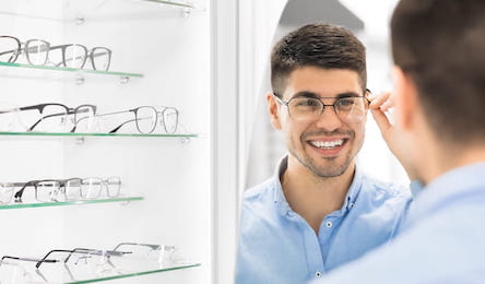 young man trying on glasses in the optical shoppe